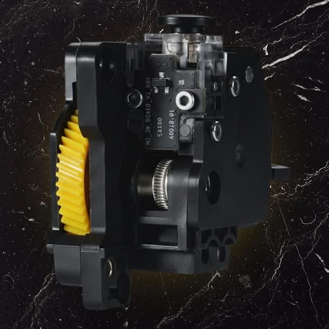 Unità di estrusione nera con un ingranaggio giallo, un ingranaggio di trazione zigrinato, una piccola scheda elettronica e una manopola nera
