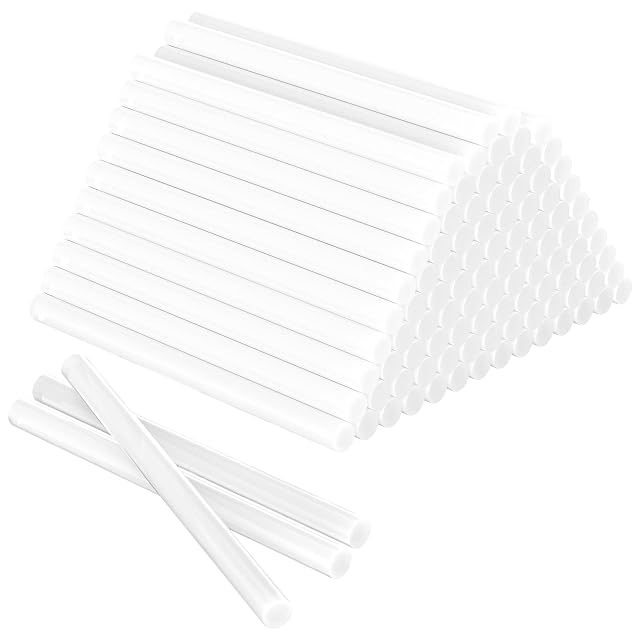 Piramide di stick di colla bianchi con tre stick sciolti davanti